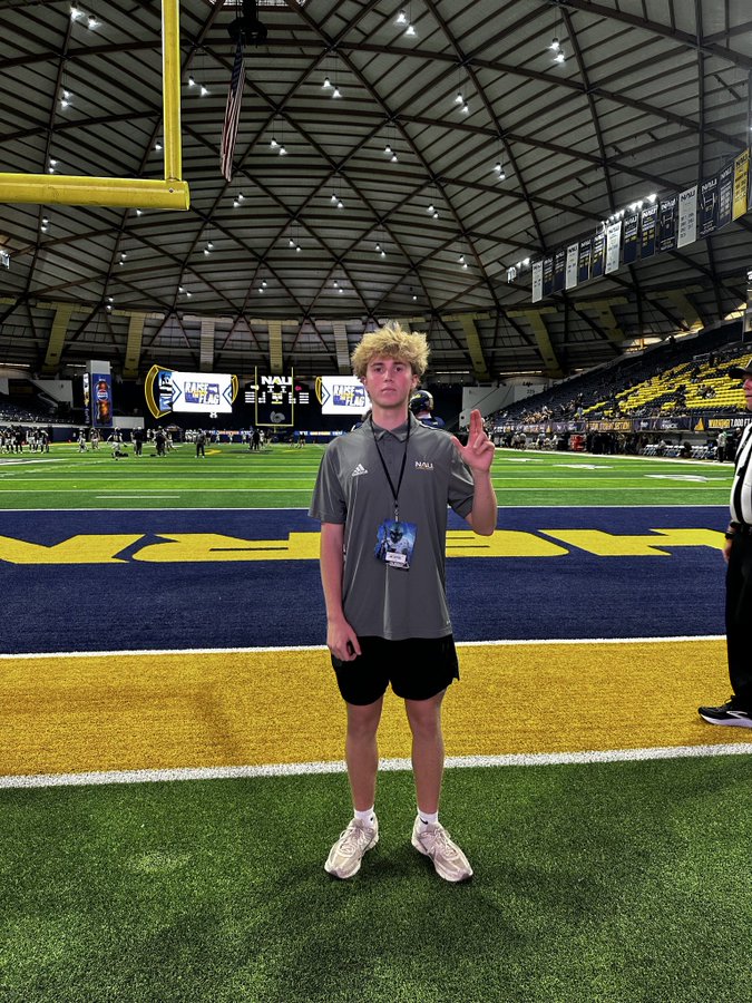 Jax Snyder on the field at Northern Arizona's Walkup Skydome with his game day visit credential