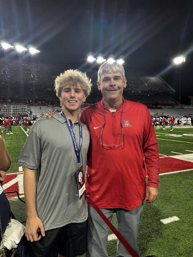 Jax Snyder with an Arizona Wildcats coach on the field at Arizona Stadium